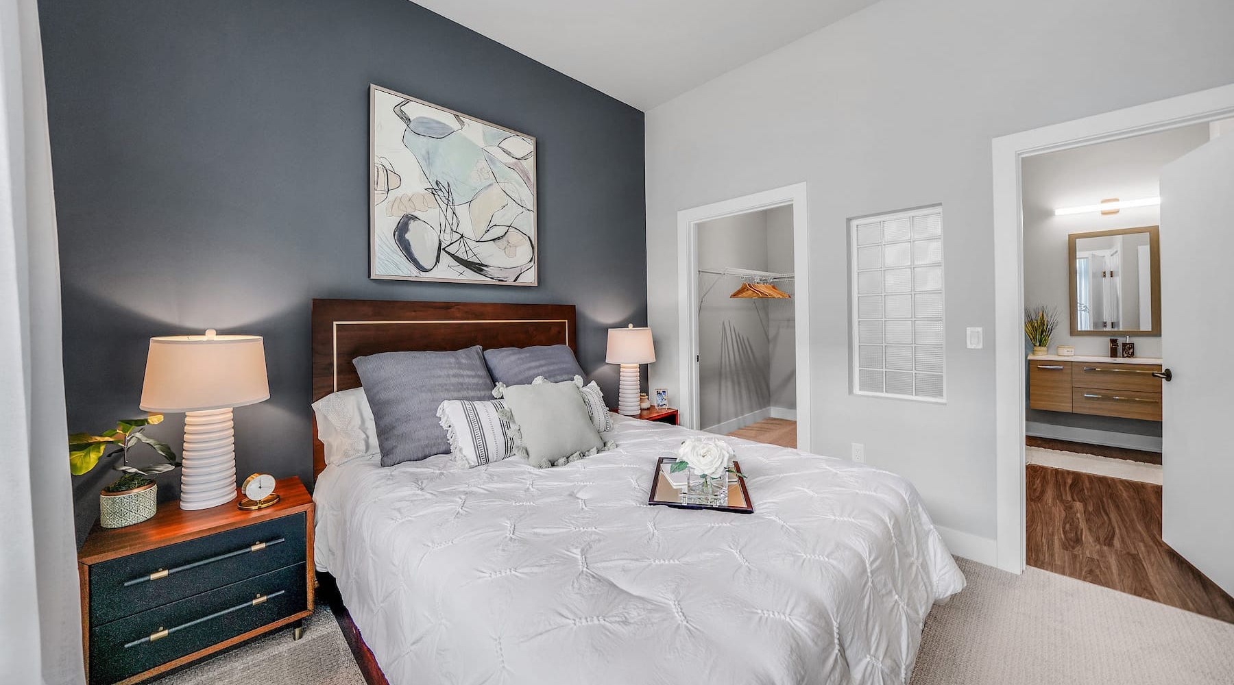 bedroom with easy access to a bathroom and with a color painted accent wall